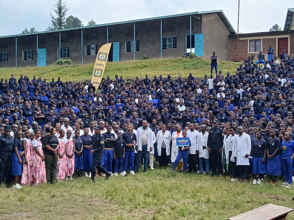 The Fight Against Drug Abuse: Marie Claire Uwineza, also known as MUTIMAWURUGO Claire, is pictured with school students, police officers, and health institution center staff dressed in white uniforms. They are gathered for a remembrance event in Rwanda. The photo shows community unity, respect, and the shared commitment to fight drug abuse and support recovery.